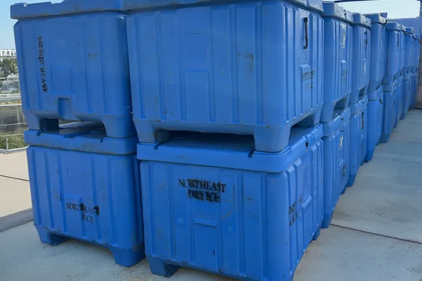 Rows of stacked Northeast Dry Ice HR-27 totes — 27 cubic feet of insulated dry ice storage each